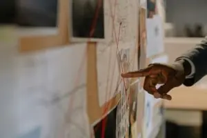 Home 6 Close-up of an investigator pointing at an evidence board with connected clues using red strings.